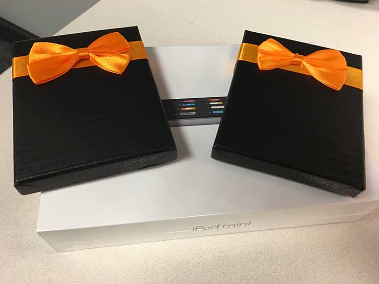 An iPad Mini and two Amazon gift boxes