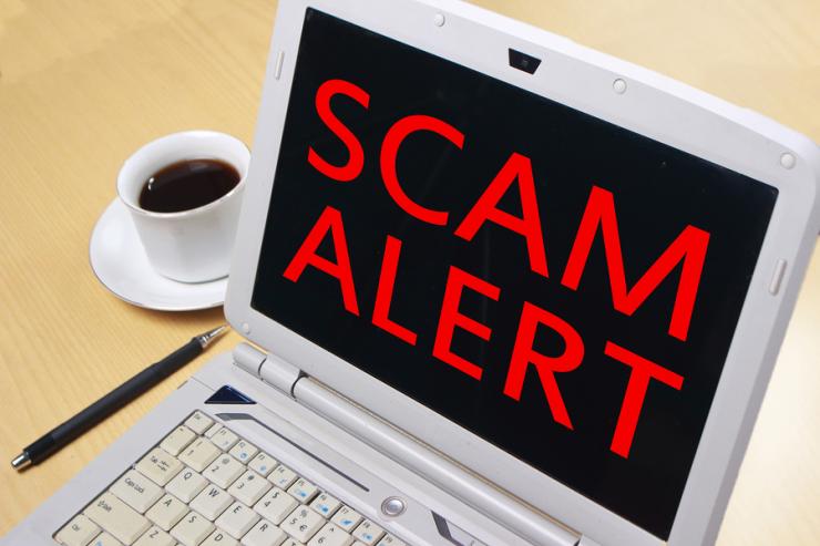 Words "SCAM ALERT" on laptop screen