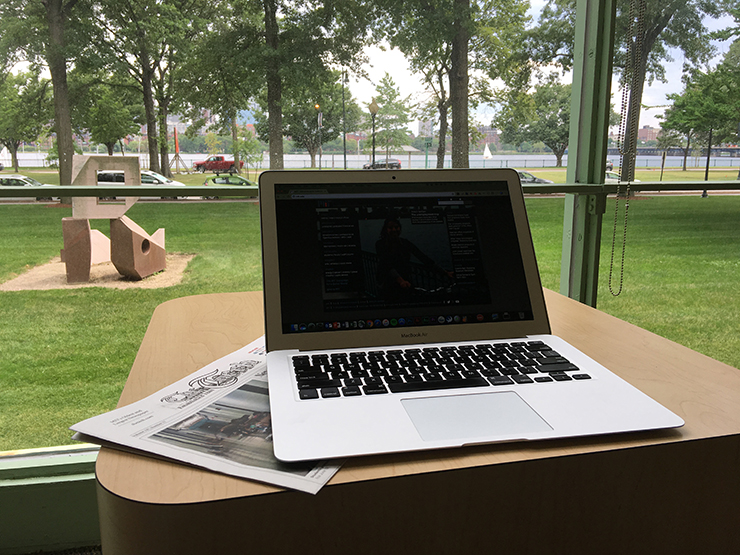 Laptop and a copy of The Tech in front of a window at Hayden Library overlooking the Charles River