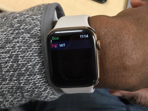 A man's wrist with an Apple Watch displaying the MIT Duo app.