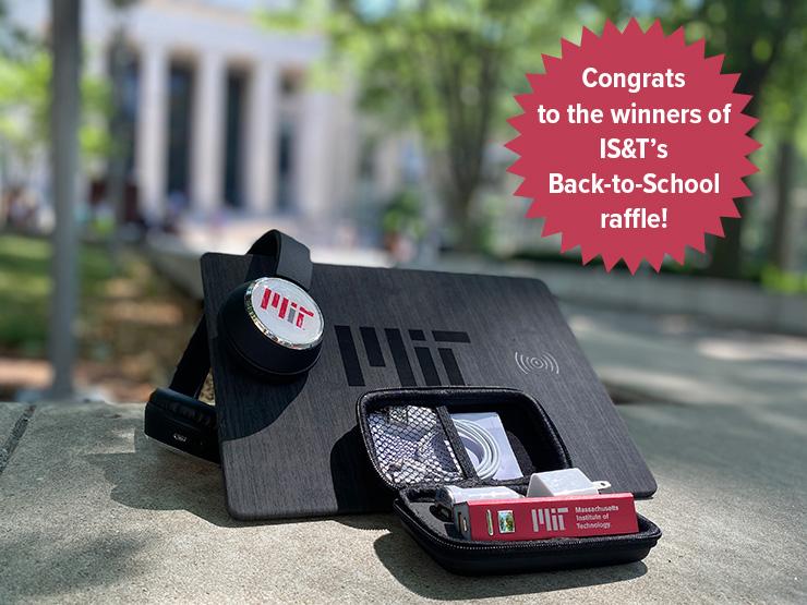 A pair of headphones, a rectangular mouse pad, and a portable phone charger, each with the M-I-T logo on it. They are on a wall with the main entrance to M-I-T at 77 Massachusetts Avenue in the background. Overlayed in the corner is a red seal and the words Congrats to the winners of I-S and T's back to school raffle.