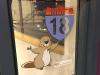 Sticker on a window of a beaver holding an MITnet 18 road sign.